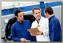 Two mechanics and their supervisor discuss a problem